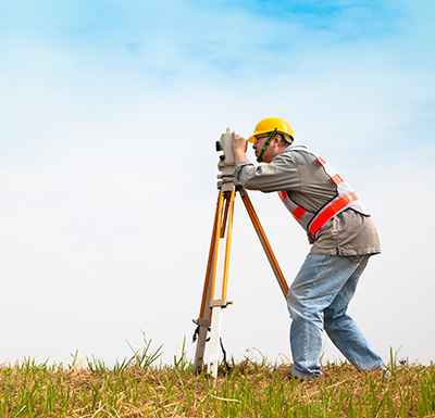 Surveyor engineer making measure on the field